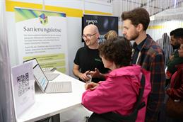 Ein HSD-Mitarbeiter stellt Besucherinnen und Besuchern den digitalen „Sanierungslotsen“ zur energetischen Gebäudesanierung bei der Nacht der Wissenschaft in Düsseldorf vor.